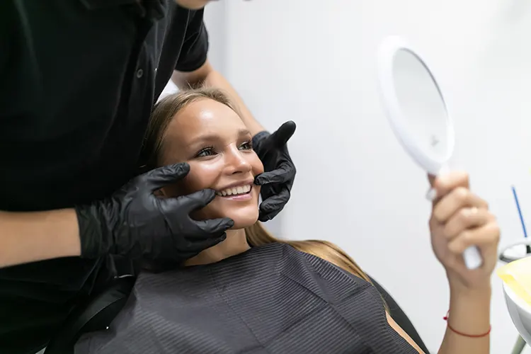 Woman having dental treatment at cosmetic dentist's office. Dentist ckeck smile of pacient